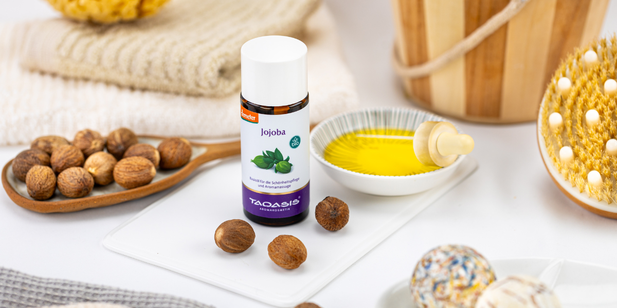 Jojobaöl von TAOASIS mit Jojobanüssen und Öl in einer Schale