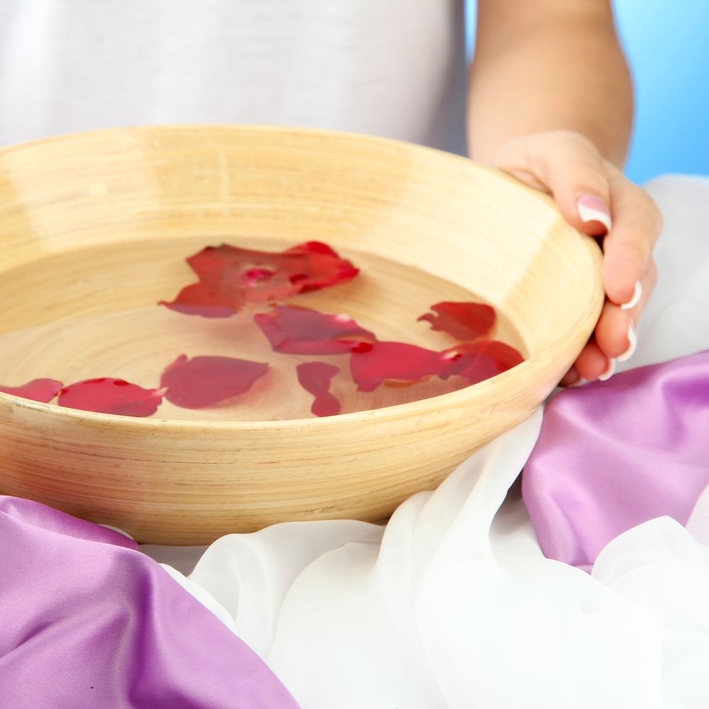 Schüssel mit Wasser mit Rosenblättern drin