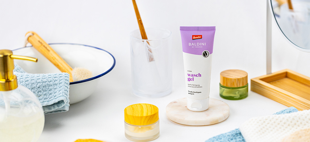Baldini mildes Waschgel in einer hellen Badezimmer-Szene mit Handtüchern, Bürste, Spiegel und natürlichen Pflegeaccessoires.