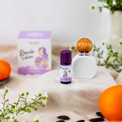 Duftkomposition Dankeschön umgeben von Blumen und Orangen.