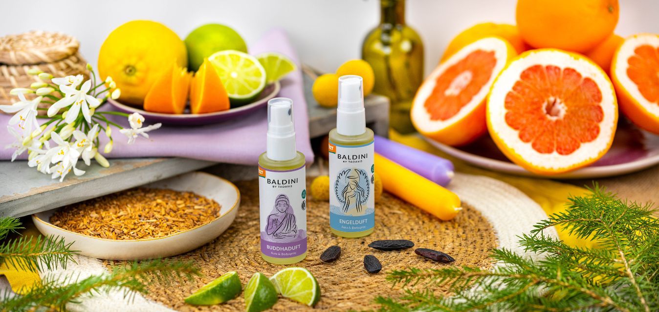 Baldini Aura- und Bodysprays „Buddhaduft“ und „Engelduft“ mit Zitrusfrüchten und Naturzutaten arrangiert.