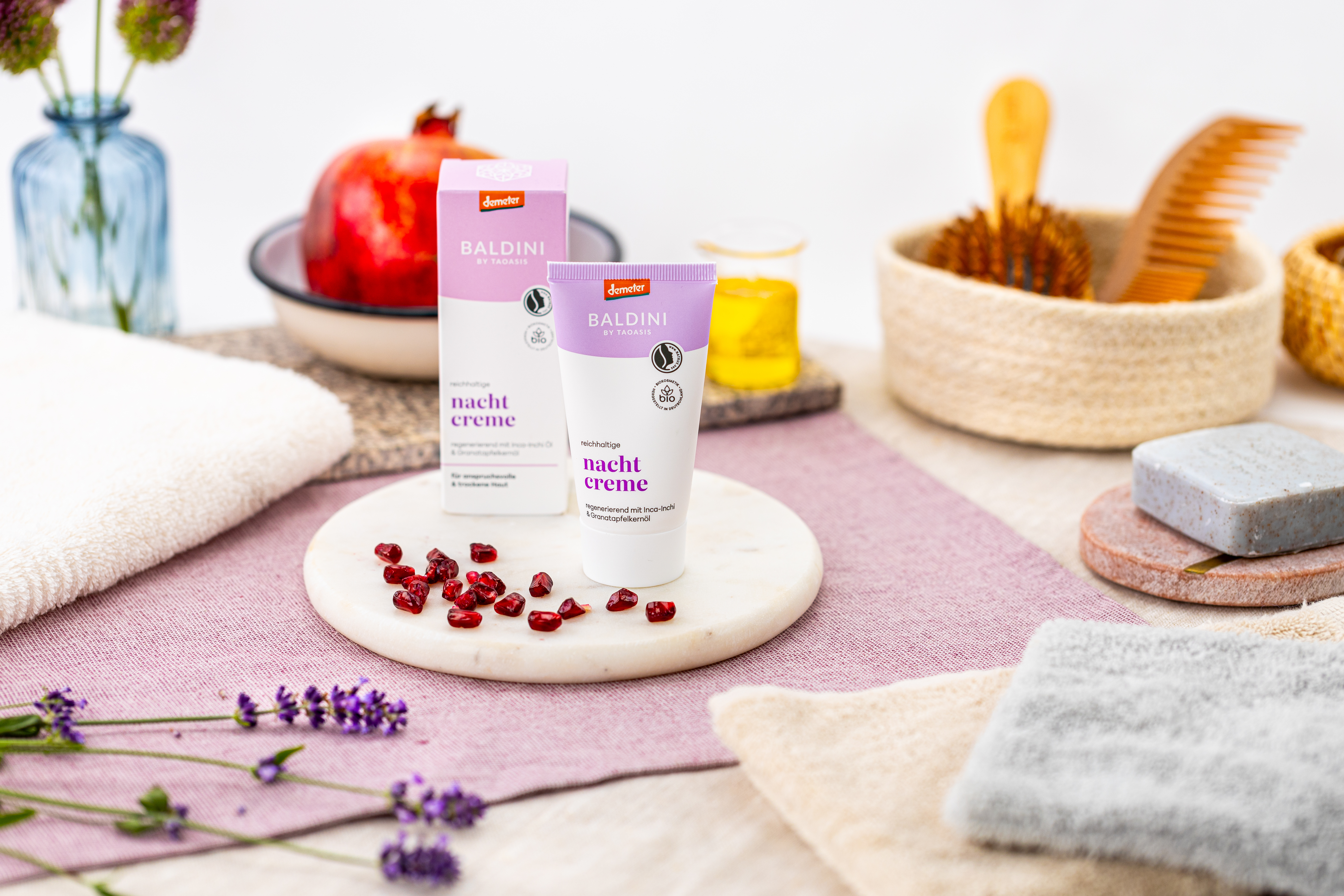 Baldini Naturkosmetik Nachtcreme auf einem Pflegearrangement mit Granatapfel und Lavendel