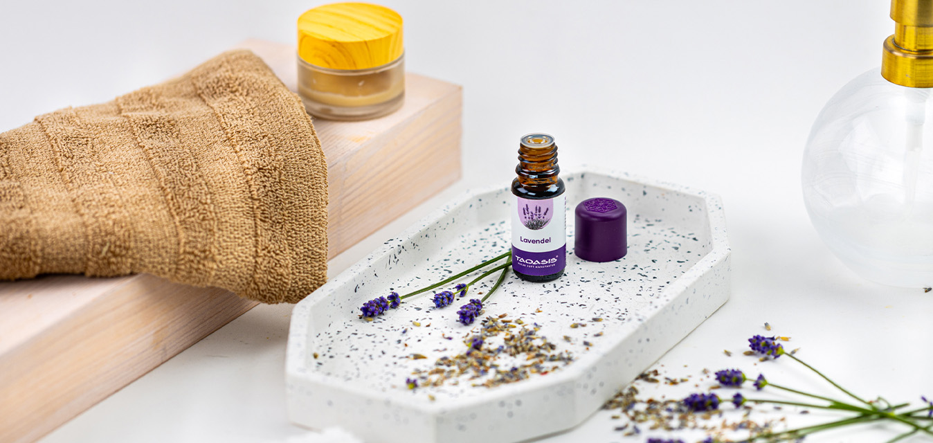 TAOASIS Lavendelöl in einer hellen Pflegeszene mit Lavendelblüten, Handtuch und natürlichen Badaccessoires.
