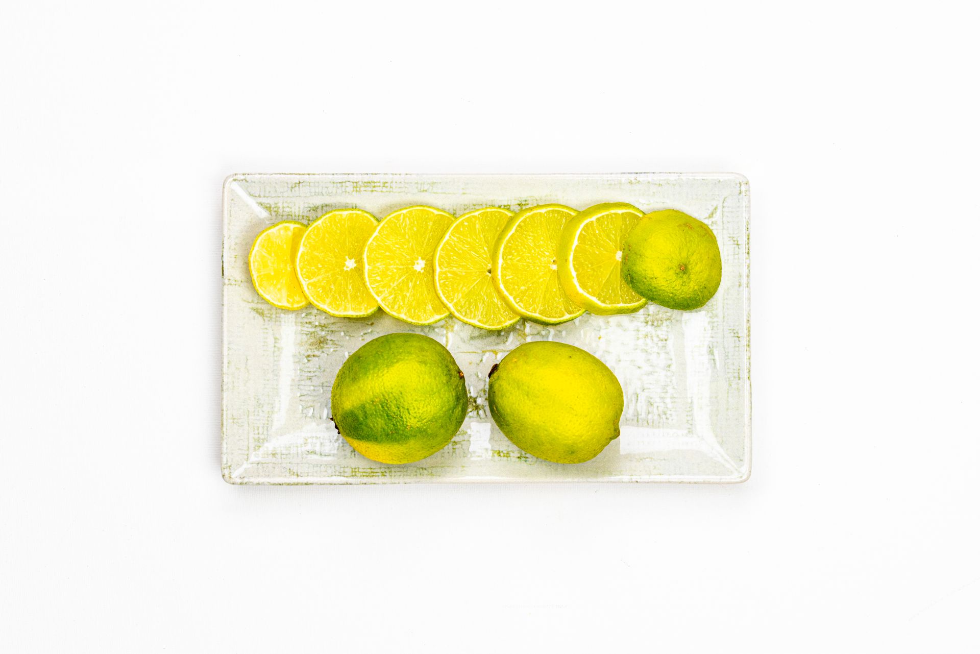 Frische Limetten und Limettenscheiben auf einem Teller