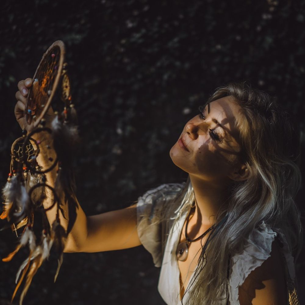 Frau mit Traumfänger in der Hand.