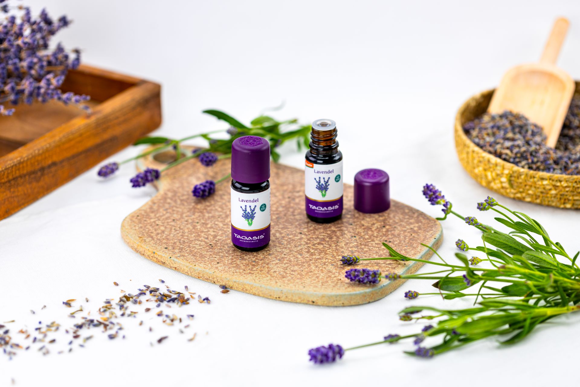 Fläschchen mit Lavendelöl neben frischen Lavendelzweigen