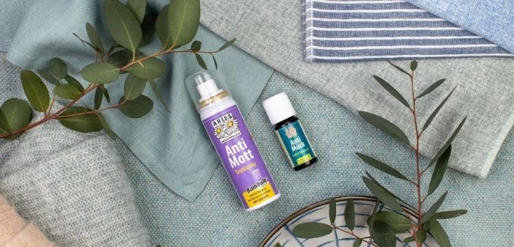 Anti Mott Textilspray und ätherisches Öl auf Stoffen mit Eukalyptuszweigen.