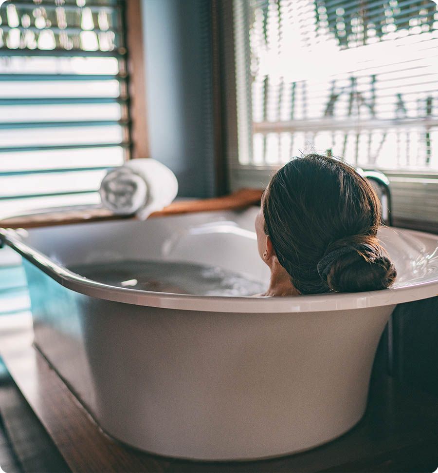 Frau liegt in der Badewanne.