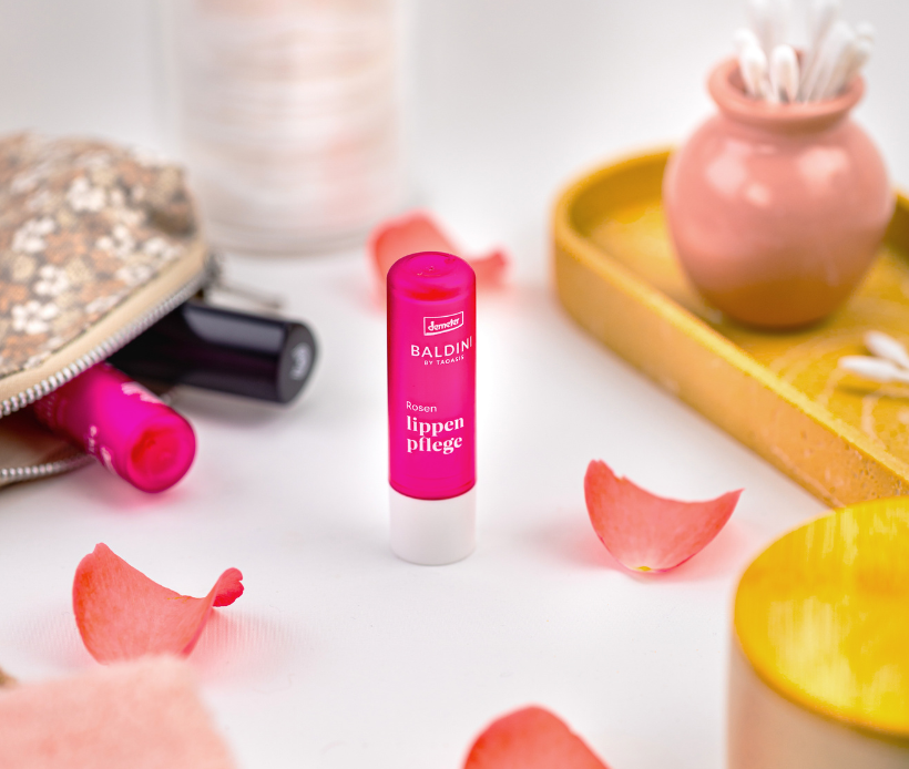 Lippenpflegestift Lavendel mit Rosenblätten als Dekoration.