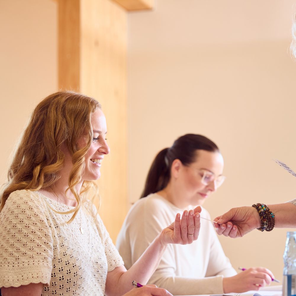 Frauen sitzen am Tisch.