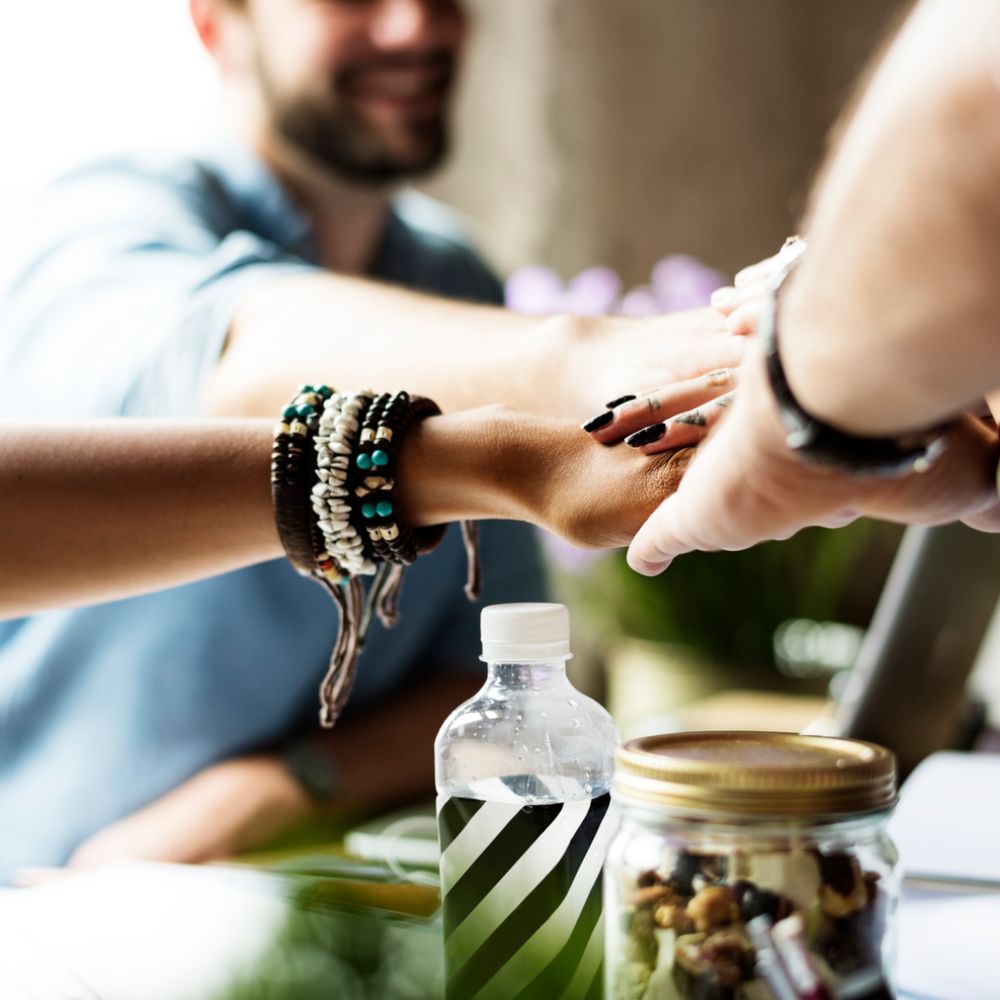 Hönde werden zusammengehalten über einem Tisch