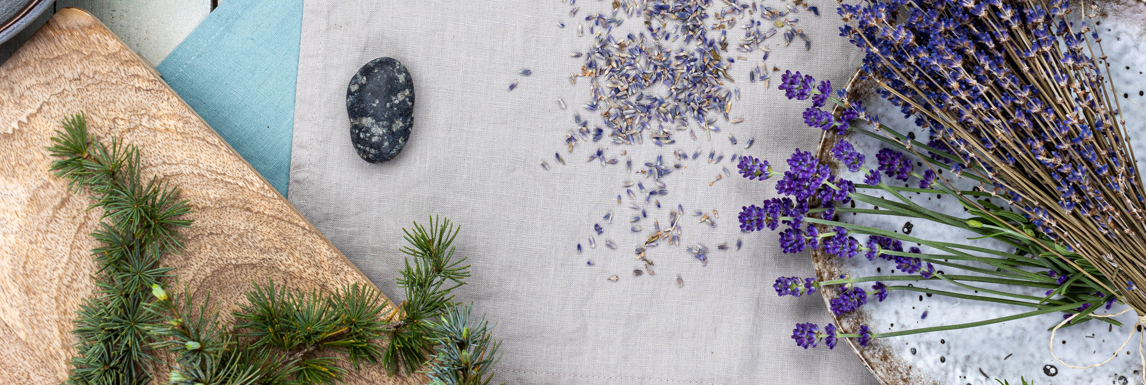 Lavendelblüten und Tannenzweige auf Naturmaterialien arrangiert