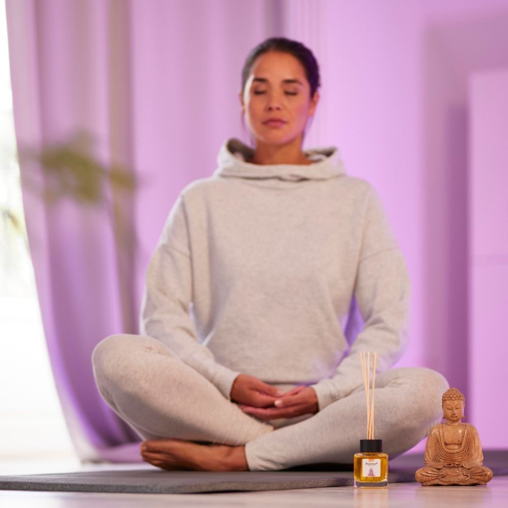 Frau macht Yoga im Schneidersitz