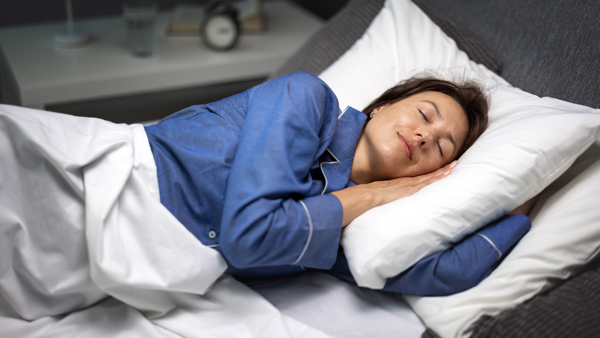 Frau schläft ruhig auf einem Kissen in ihrem Bett.