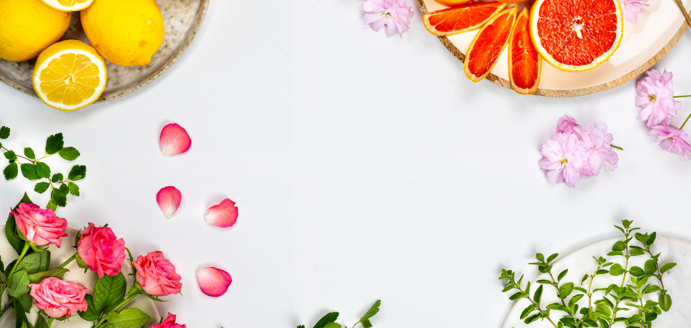 Zitrusfrüchte, Rosen und Kräuter dekorativ auf hellem Hintergrund