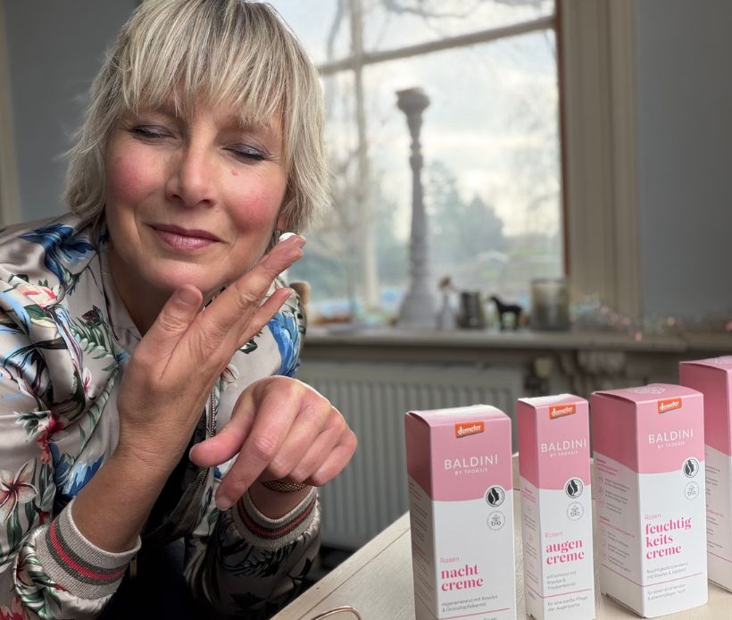 Frau, die sich die Baldini Naturkosmetik Rose im Gesicht aufträgt