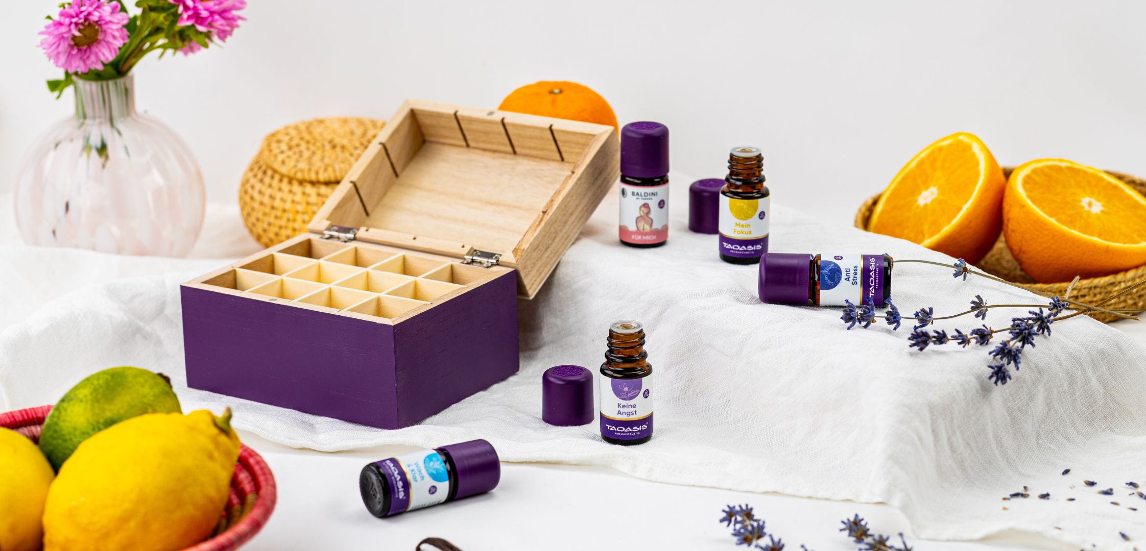 Offene Duftbox Achtsamkeit mit Duftkompositionen von Taoasis und Baldini, umgeben von Lavendelzweigen und frischen Zitrusfrüchten.
