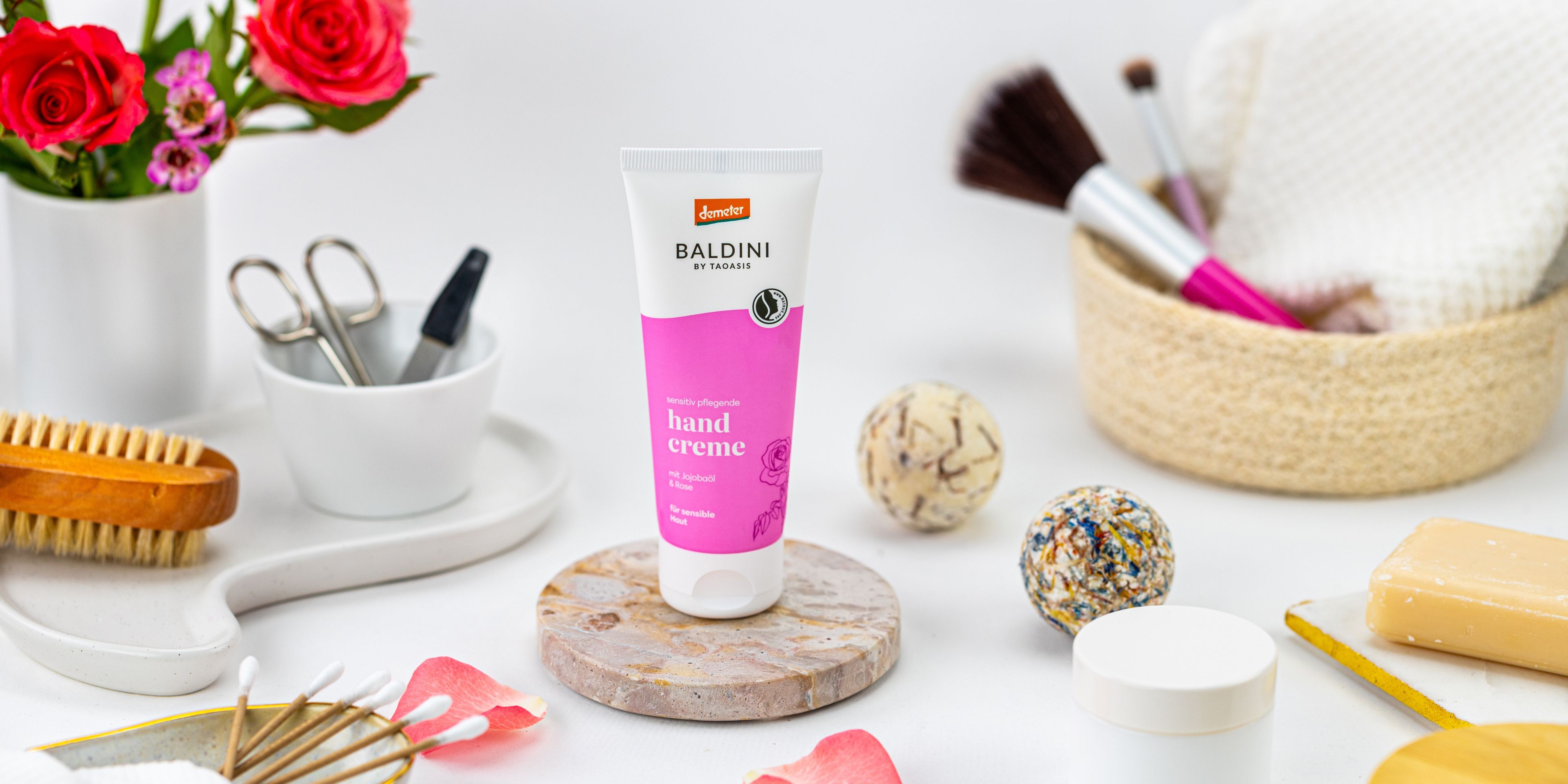 Baldini Handcreme Rose mit Make-Up Utensilien und Bluemndekoration.