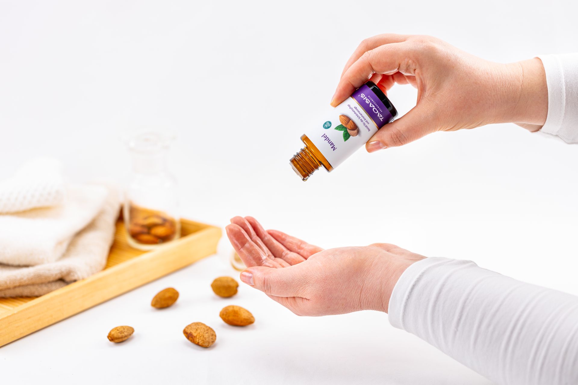 Mandel Basisöl von TAOASIS wird in die Hand getropft